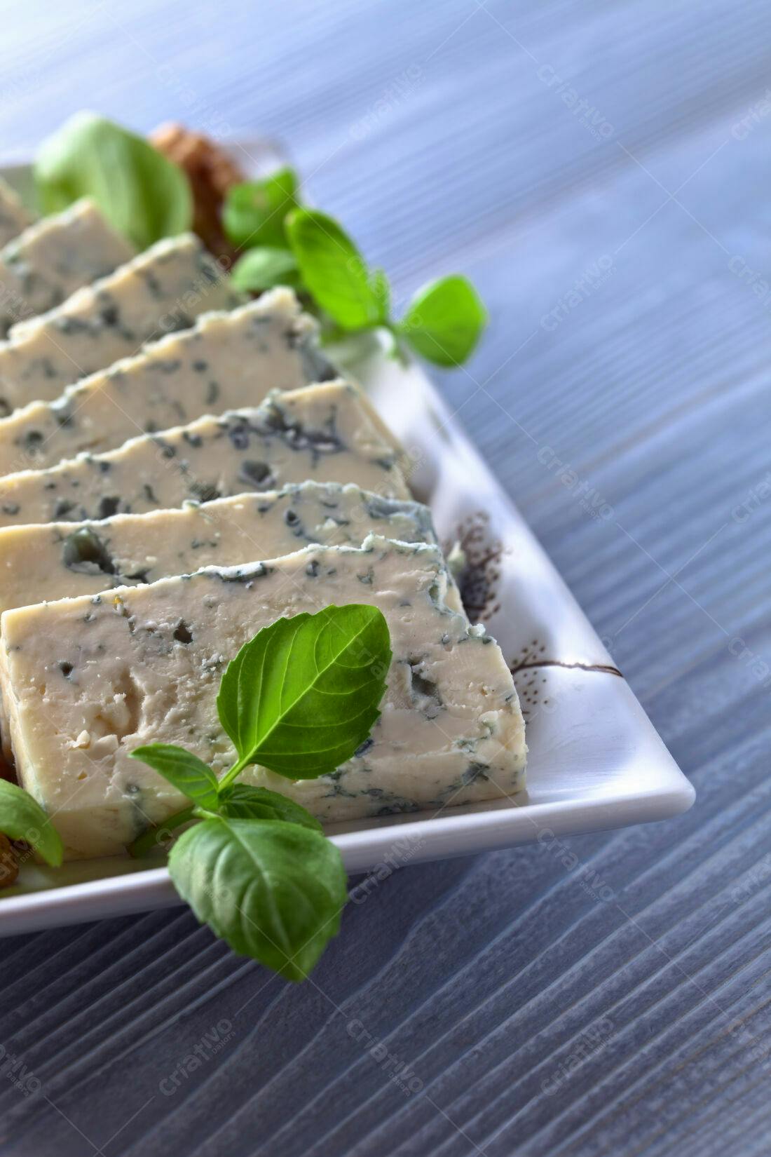 Queijo Roquefort fatiado com manjericão