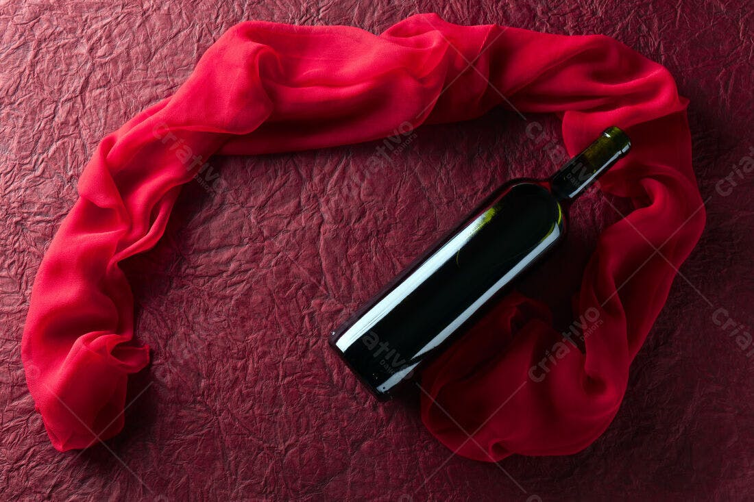 Garrafa de vinho tinto sobre tecido vermelho