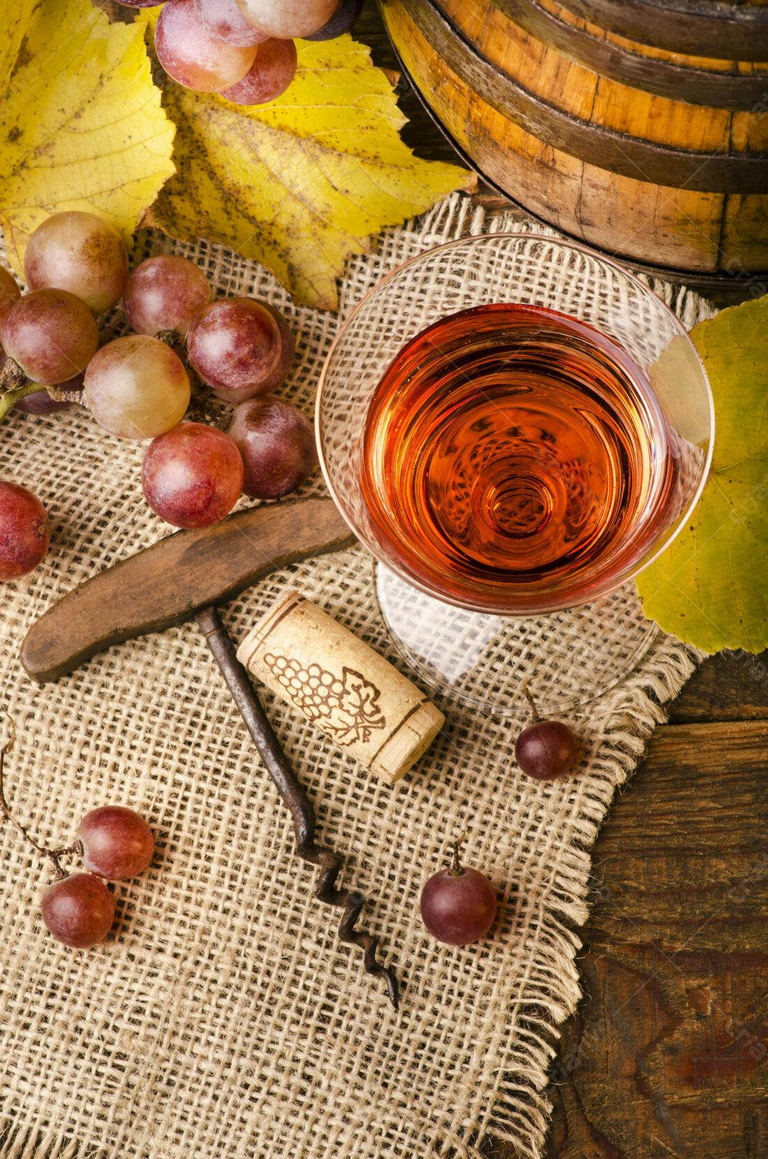Taça de vinho tinto uvas e saca rolhas