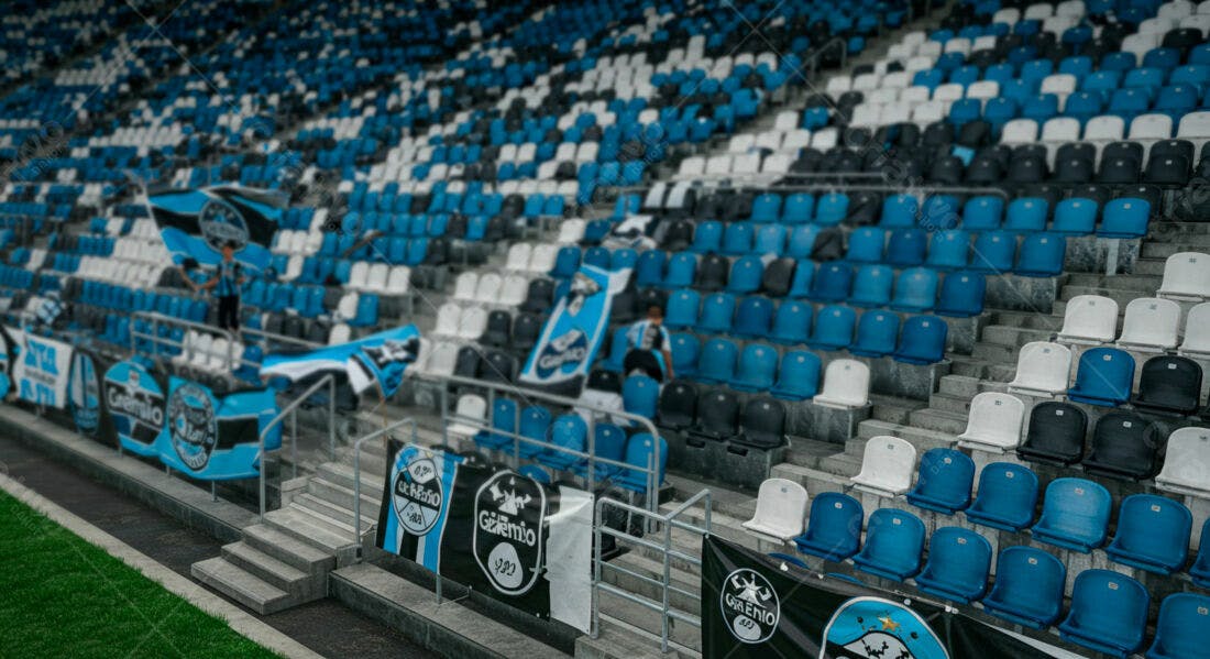 Arquibancada de estádio vazia com bandeiras