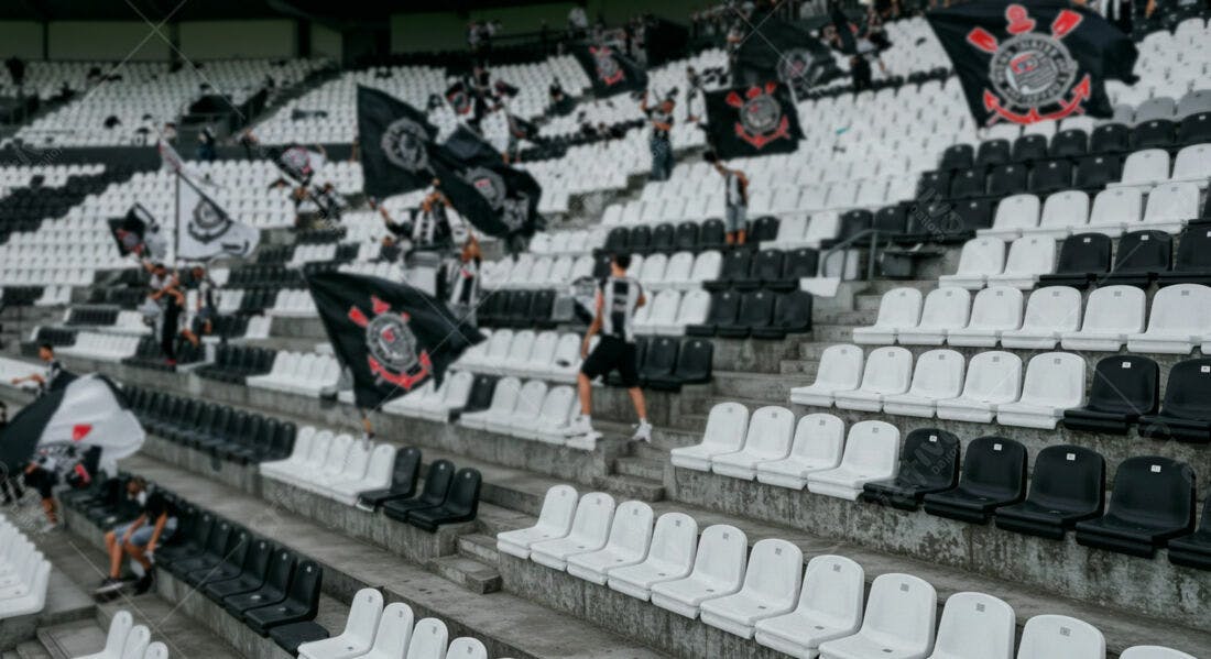 Torcida em estádio com bandeiras preto e branco