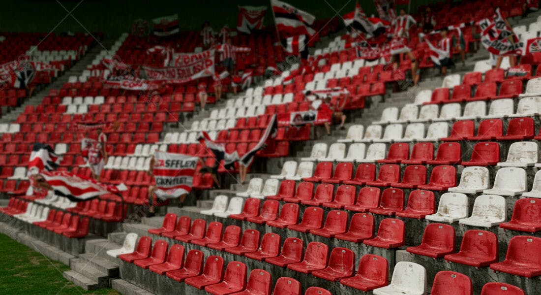 Arquibancada de estádio com torcedores e bandeiras