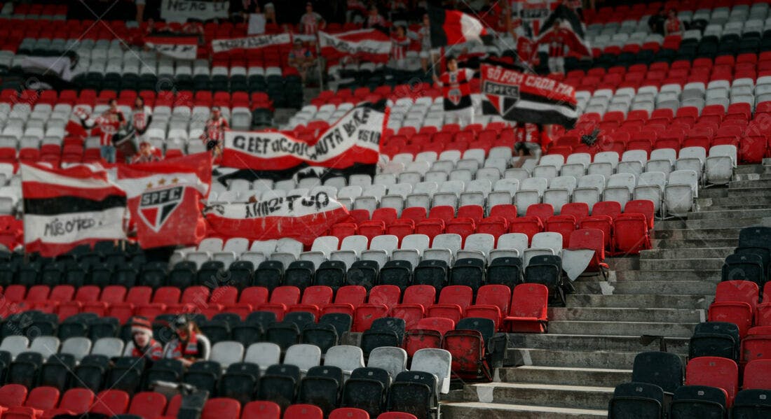 Torcida em estádio com bandeiras vermelho e branco
