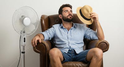 Homem com calor , perto de ventilador branco
