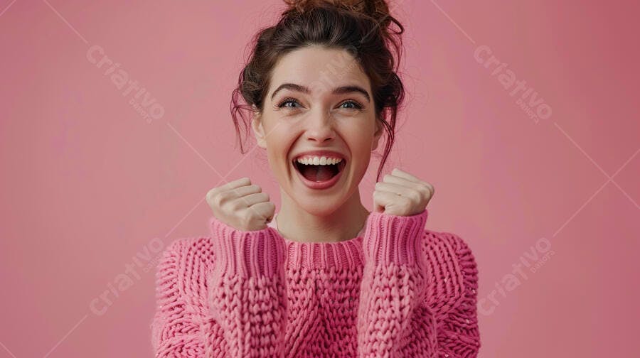 Mulher feliz em suéter rosa comemorando