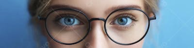 Mulher com Olhar Intenso e Detalhado Através das Lentes de um Óculos em Fundo Azul