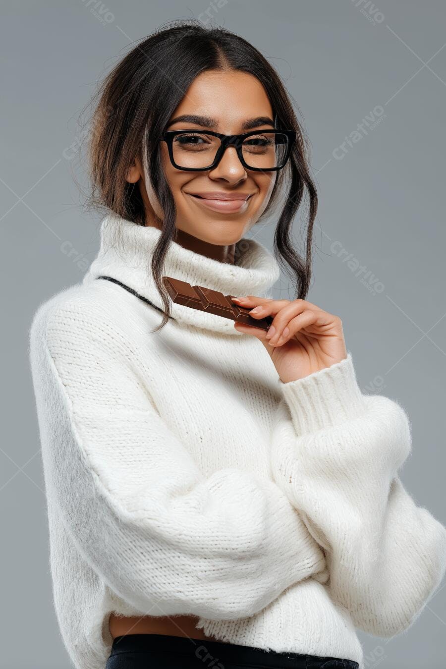 Mulher com óculos e suéter branco segurando chocolate