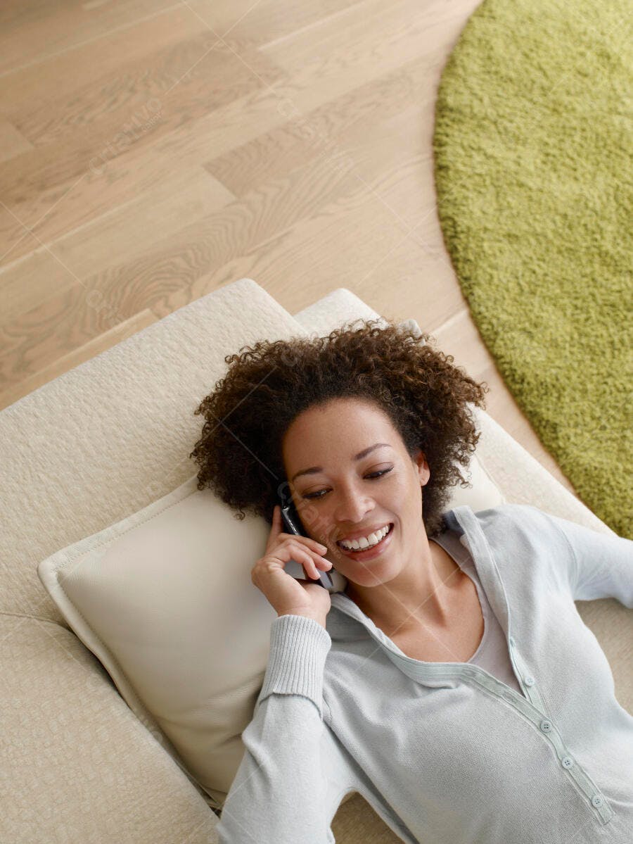 Mulher negra sorridente ao telefone em casa