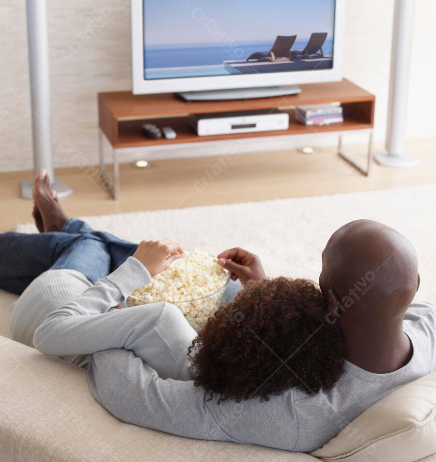 Casal Afro-americano assistindo TV com pipoca