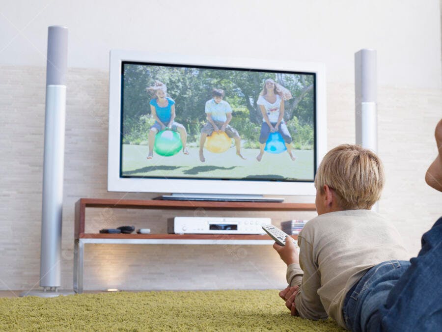 Menino assistindo TV com programa infantil