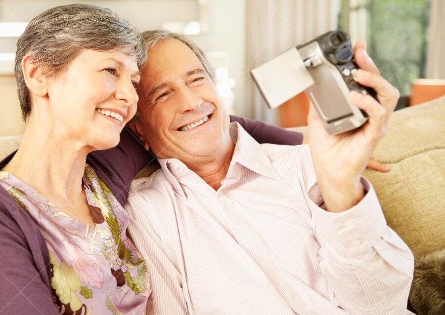 Casal Sênior Feliz com Filmadora em Casa