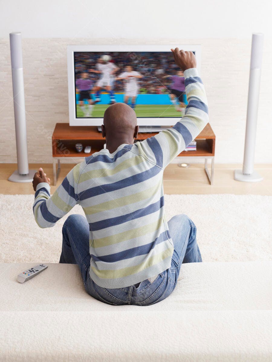 Homem assistindo futebol na TV