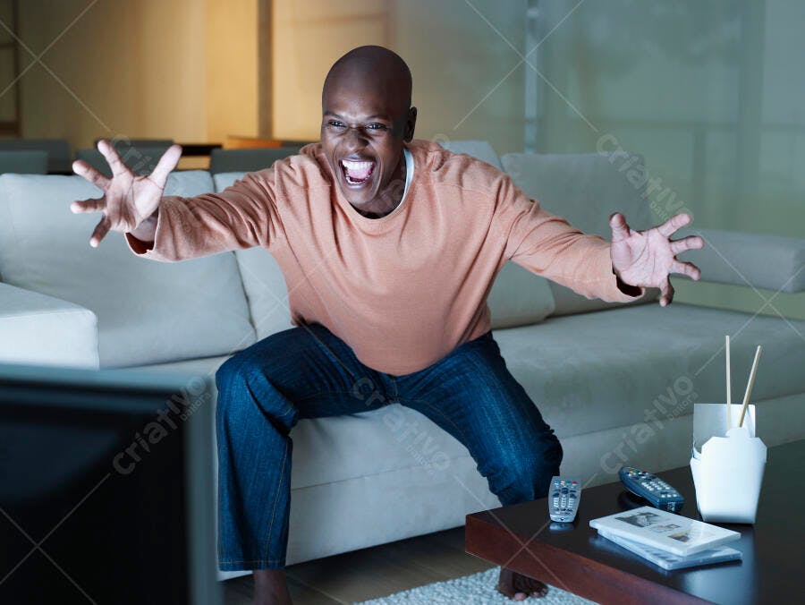 Homem assistindo TV em casa à noite