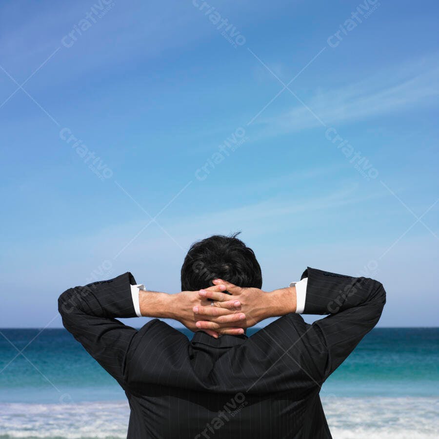 Executivo relaxando na praia sob céu azul