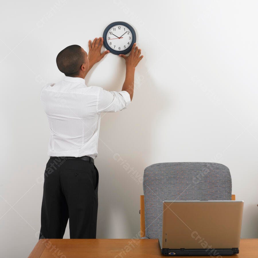 Homem instalando relógio na parede do escritório