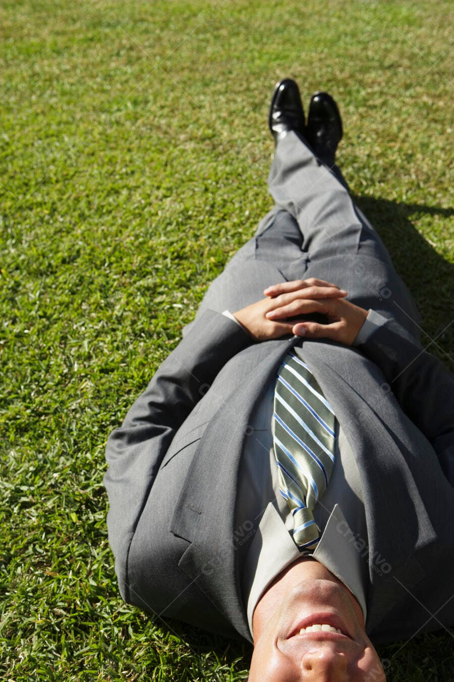Homem de terno relaxando na grama