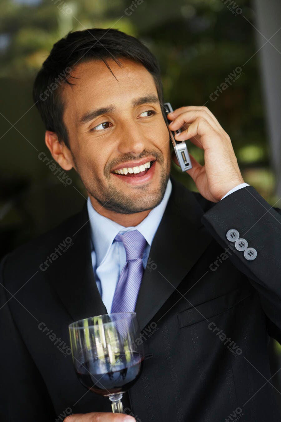 Homem de Negócios Sorrindo ao Telefone com Taça de Vinho