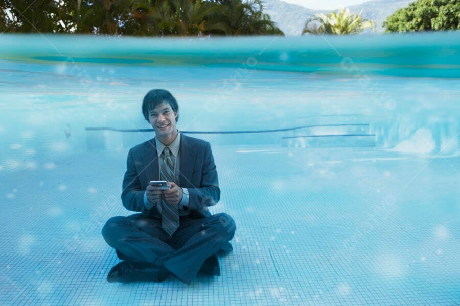 Homem de negócios usando celular na piscina