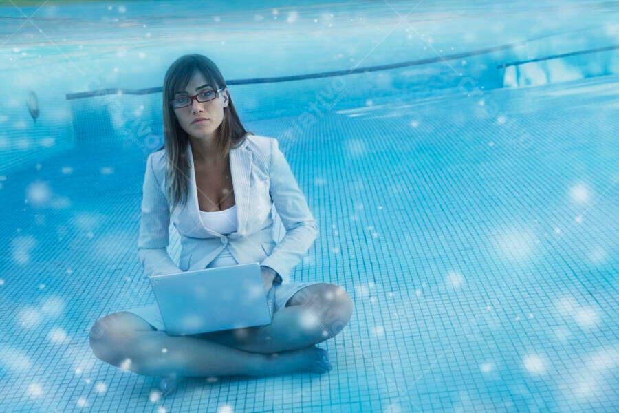 Mulher executiva com laptop na piscina vazia