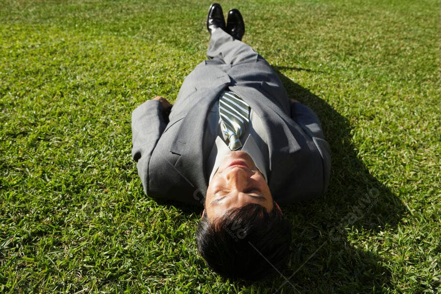 Homem de terno descansando na grama