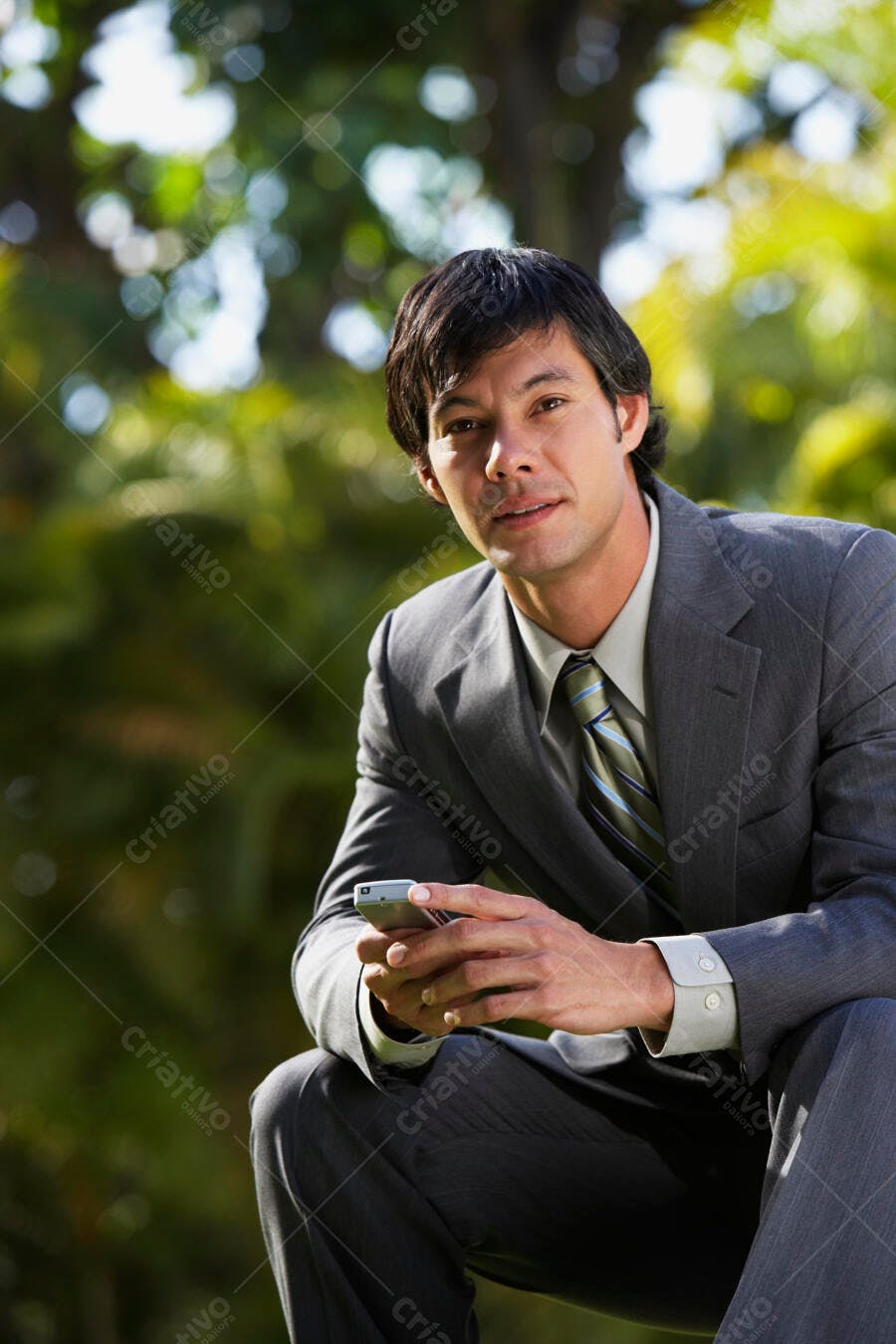 Executivo Asiático com celular em parque