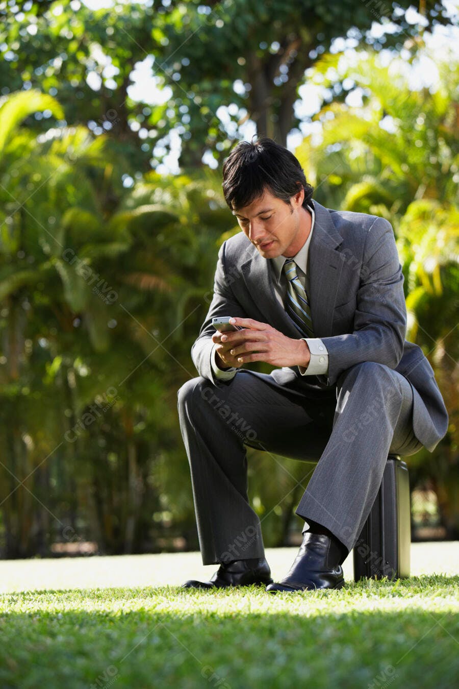 Executivo lendo mensagem em celular parque