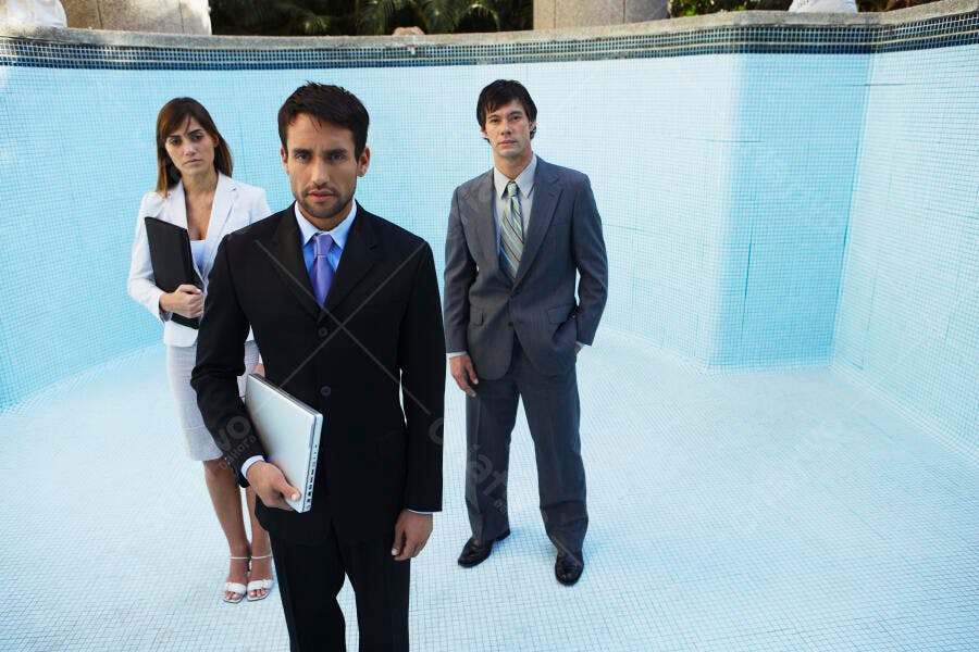 Executivos em piscina vazia