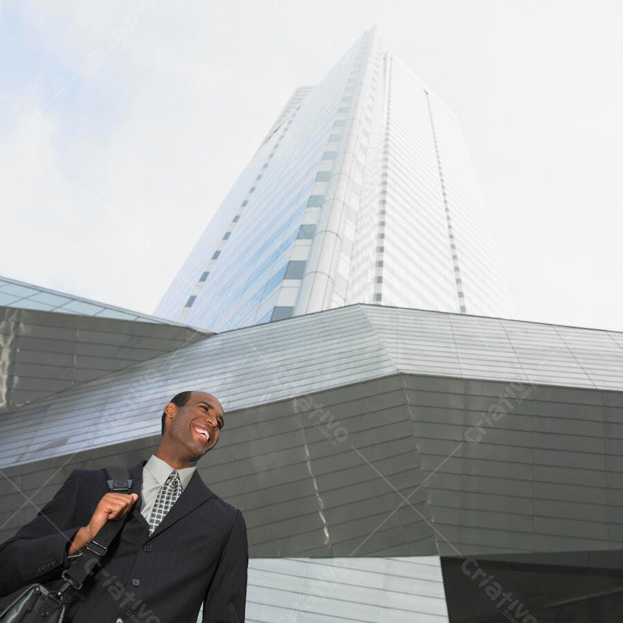 Homem negro sorridente em centro financeiro moderno