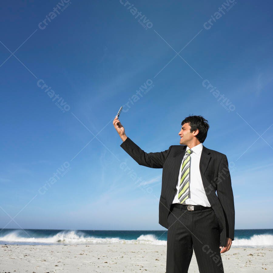 Homem de negócios tirando selfie na praia