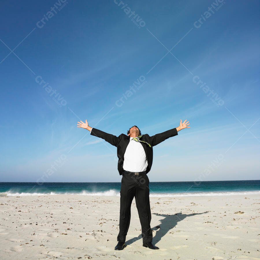 Homem de terno na praia celebrando sucesso