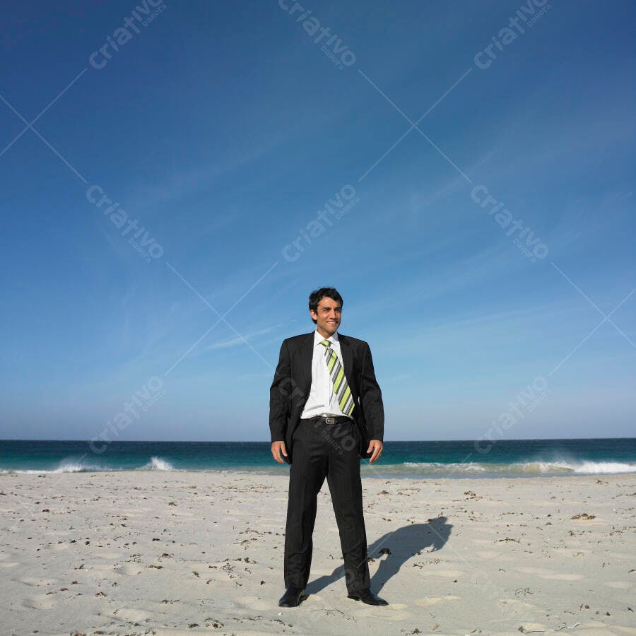 Executivo na praia sorrindo sob céu azul