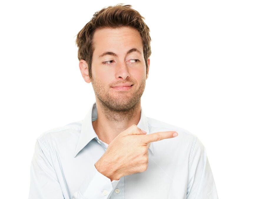 Homem apontando para o lado sorrindo