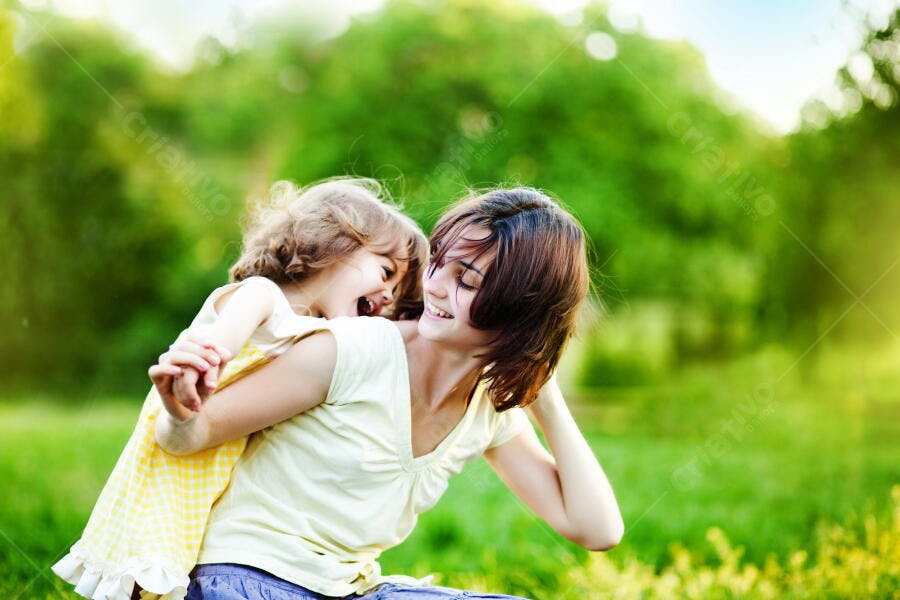 Mãe e filha brincando em parque verde
