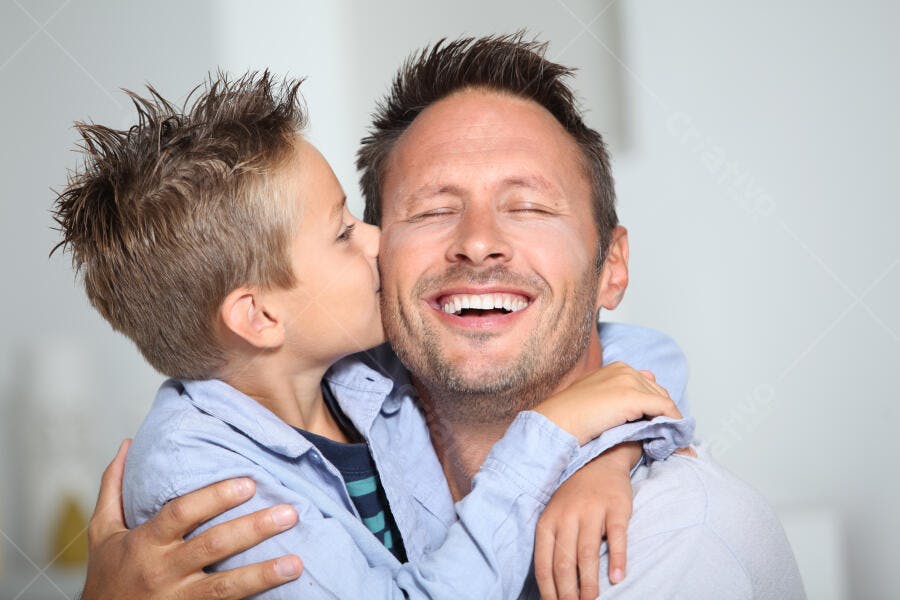 Menino beijando pai feliz em casa
