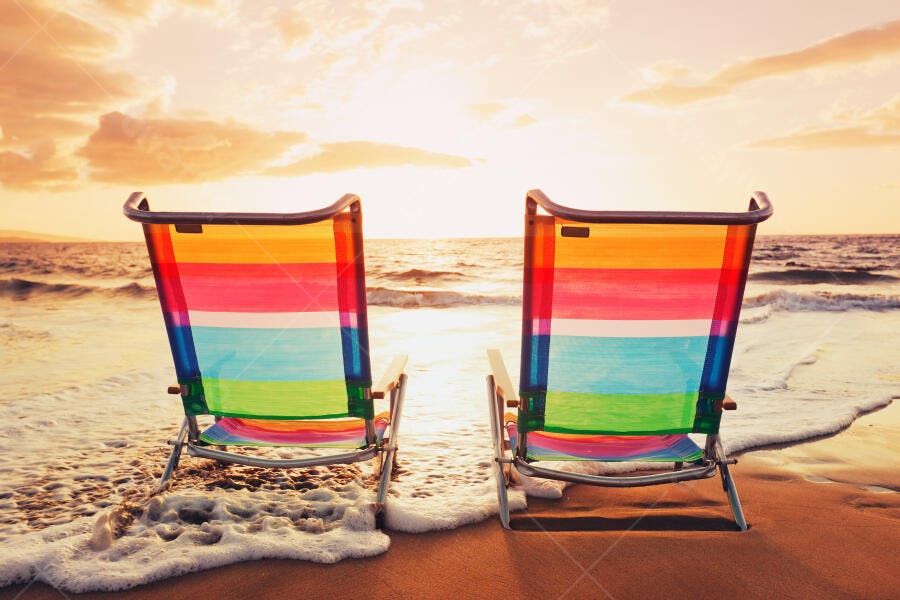 Cadeiras na praia ao pôr do sol