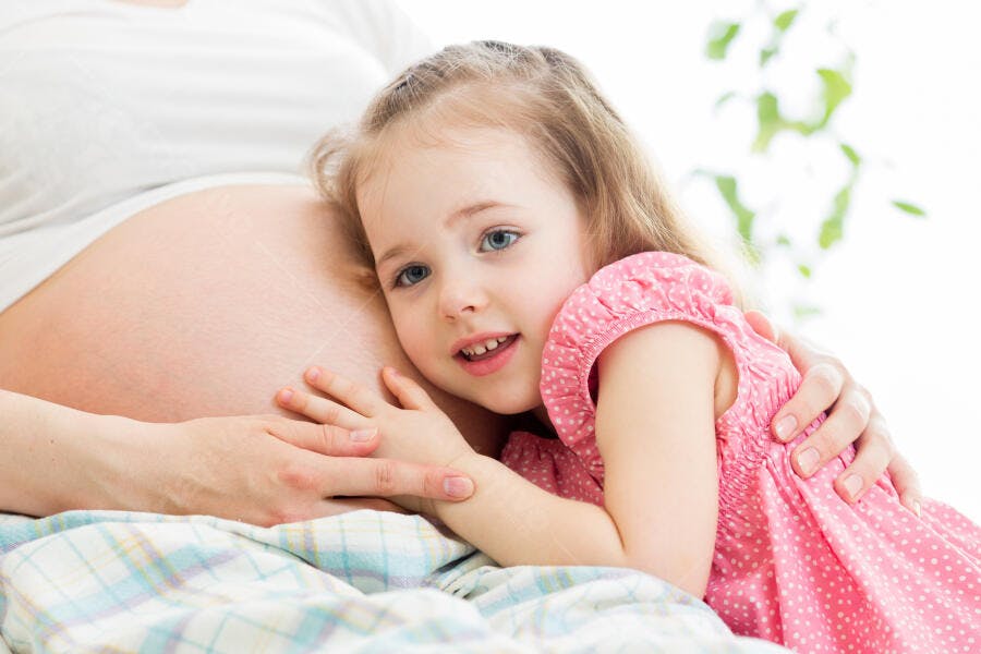 Menina abraçando barriga de grávida