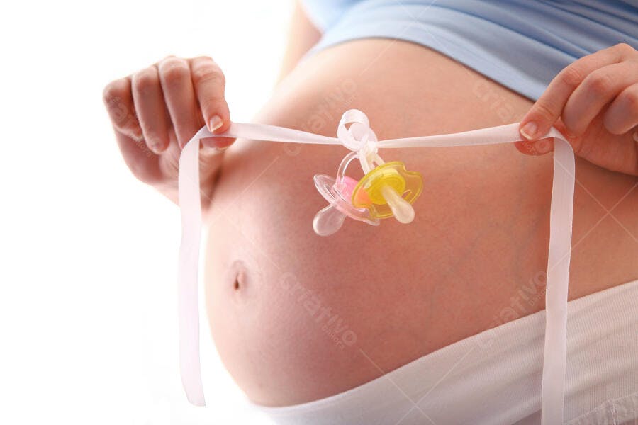 Barriga de grávida com chupetas e fita