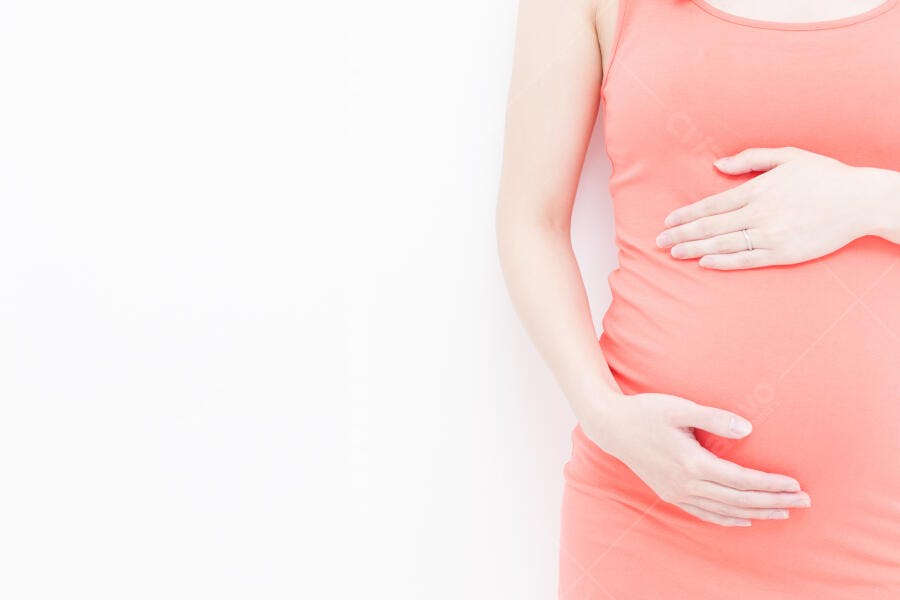 Barriga de grávida em vestido coral