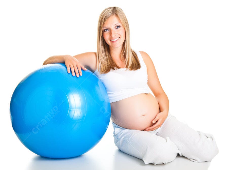 Grávida feliz com bola de pilates azul