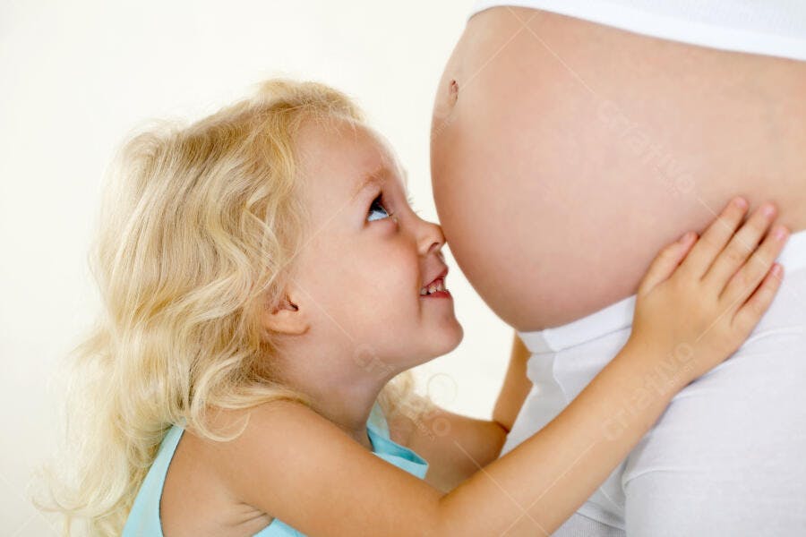 Menina loira abraçando barriga grávida