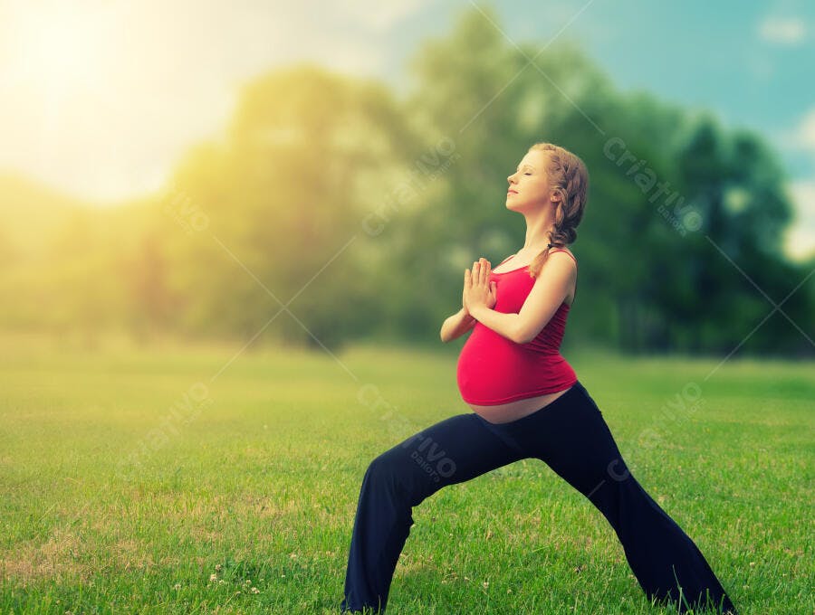 Grávida praticando Yoga em parque ensolarado