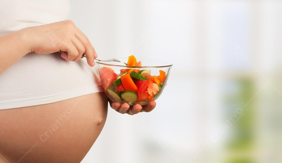 Mulher grávida comendo salada colorida