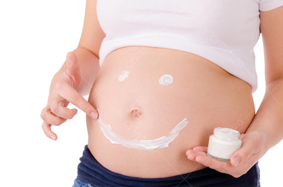 Barriga grávida com creme sorrindo