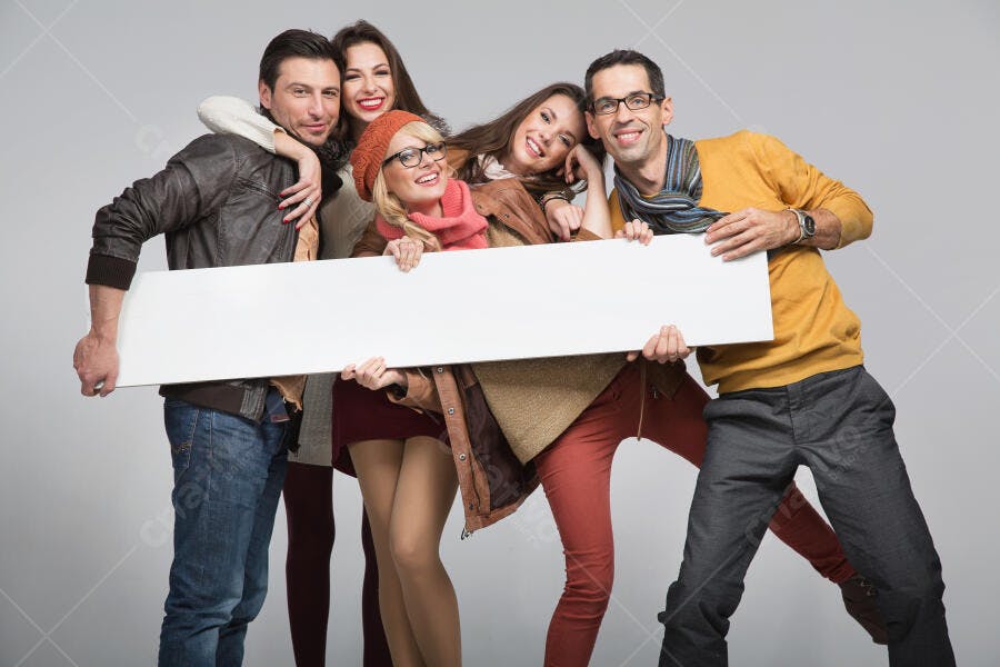 Amigos sorrindo segurando cartaz branco