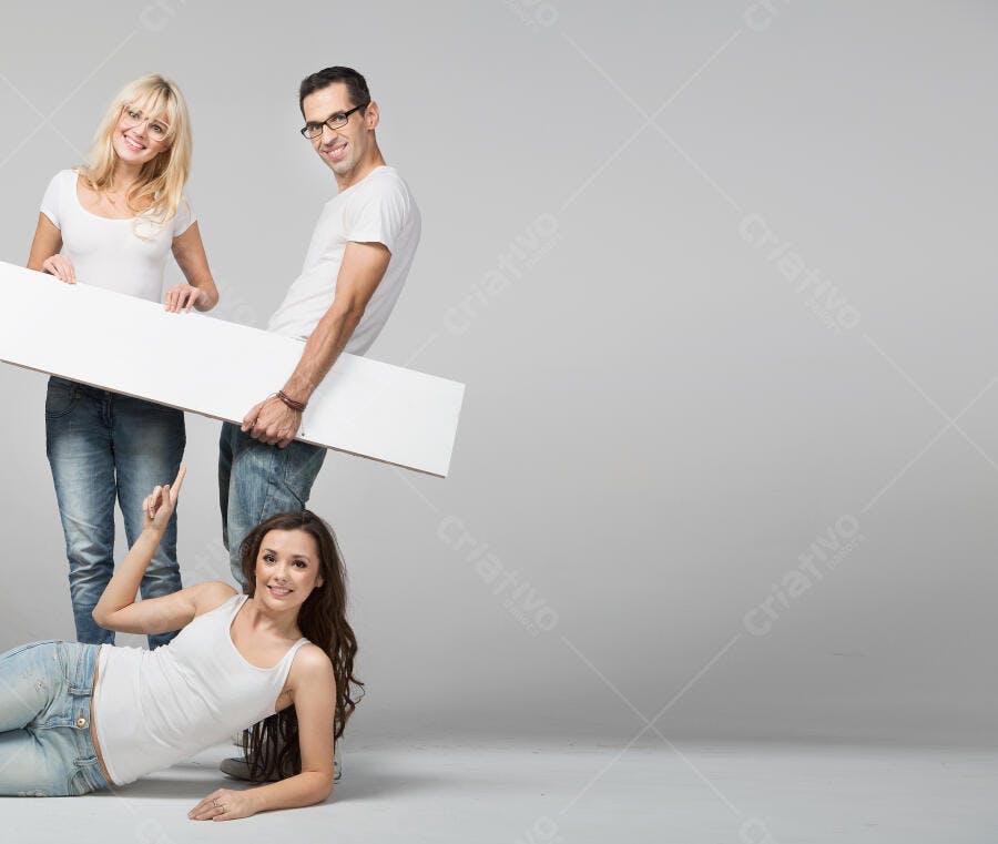 Três jovens segurando placa branca fundo cinza
