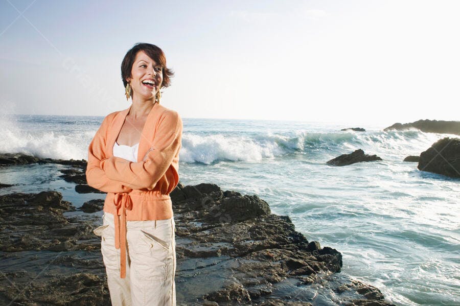 Mulher feliz na praia com ondas fortes