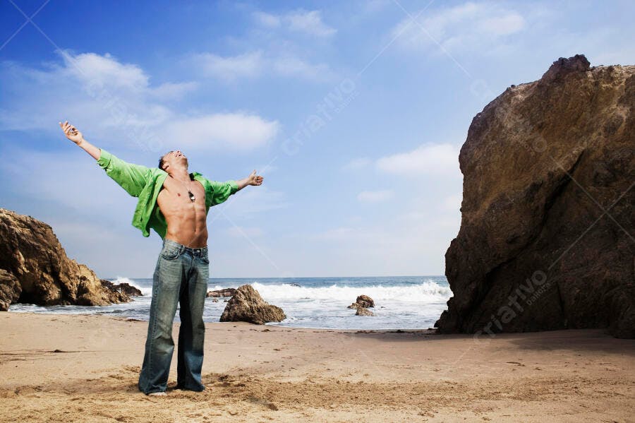 Homem feliz na praia com braços abertos