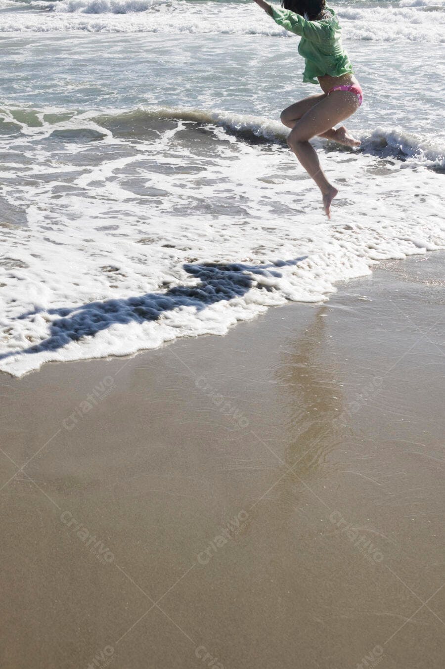Mulher pulando onda na praia