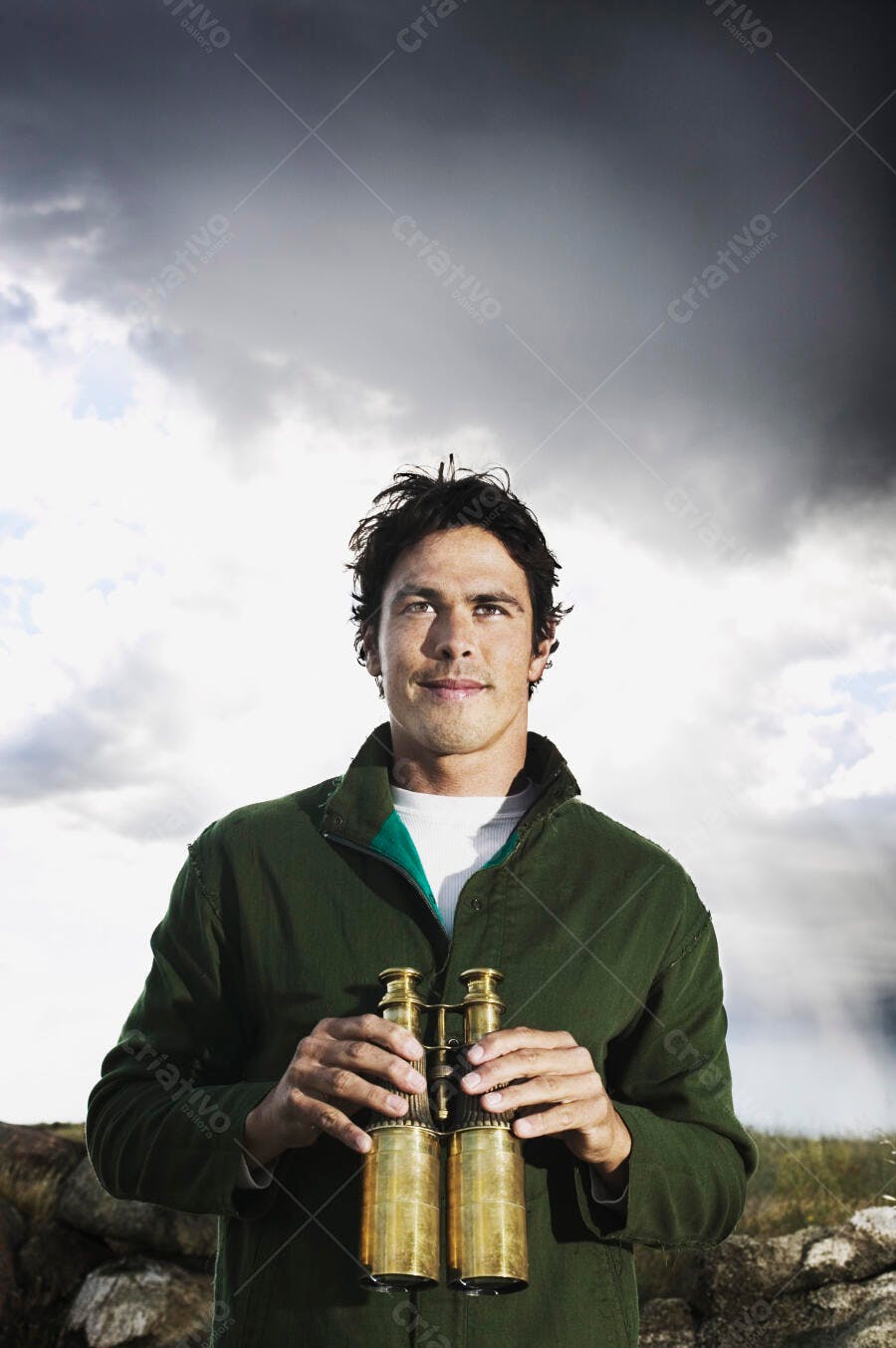 Homem segurando binóculos paisagem nublada