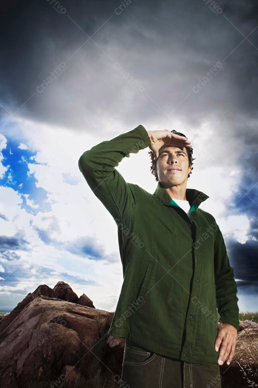 Homem observando paisagem sob céu dramático